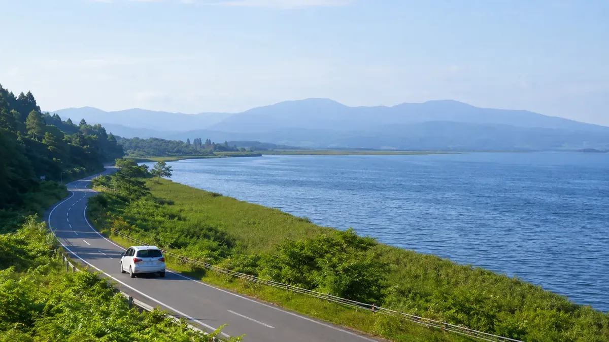 青森県津軽半島、十三湖畔を走るレンタカーと穏やかな夏の風景